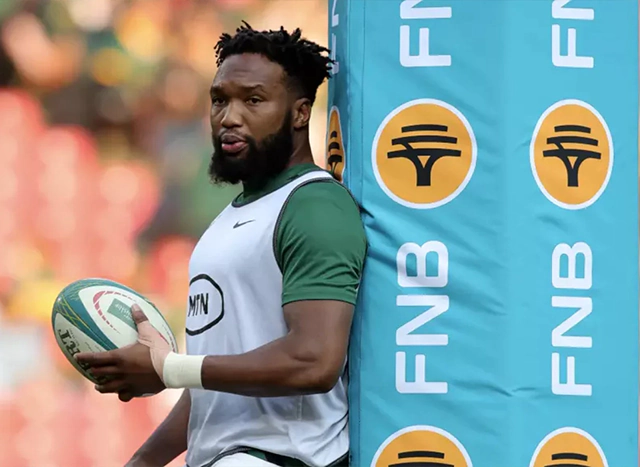 Lukhanyo Am standing by FNB branded upright pole cushion
